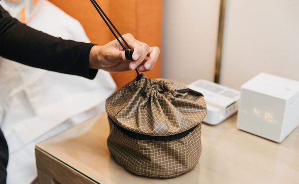 A person sliding the locking slider down to seal closed a Travel Tray.